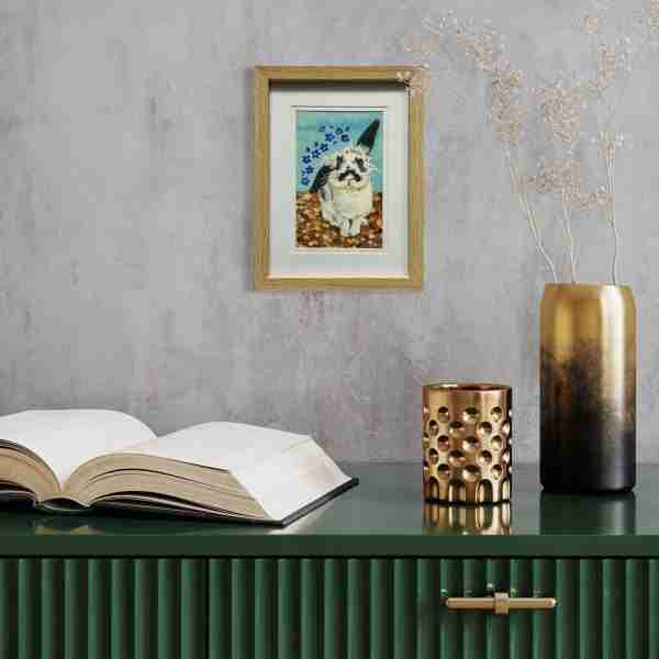 Watercolour bunny art on a wall with a green cabinet underneath