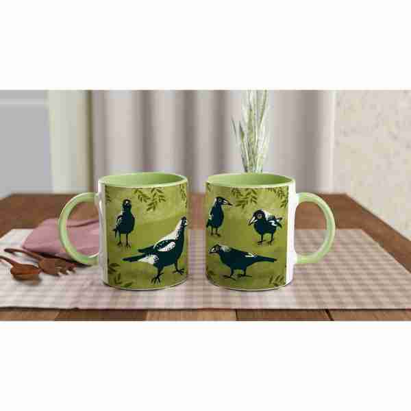 Two coffee mugs with Australian magpies design on a table