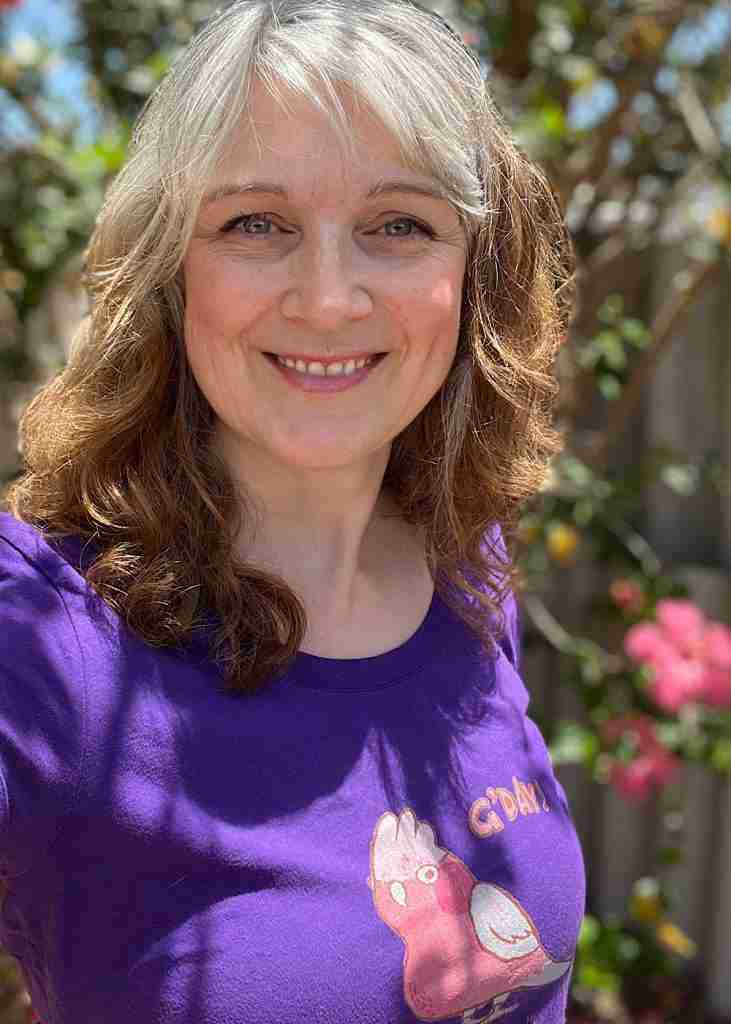 IMG_6741 Photograph of Bunbury, WA artist Bee Denham wearing a purple t-shirt featuring a galah design
